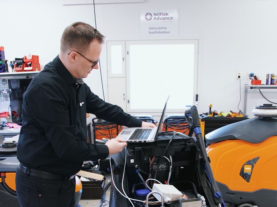 Huoltomekaanikko tekee vianetsintää kannettavalla tietokoneella